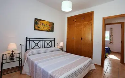 a bedroom with a large bed with a white blanket at Casa Juani in Conil de la Frontera