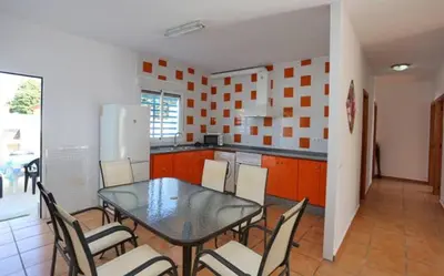 a kitchen with a table and chairs and a refrigerator at Casa Juani in Conil de la Frontera