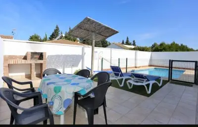 a patio with a table and chairs and a pool at Casa Juani in Conil de la Frontera