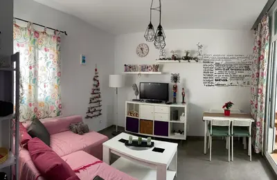 a living room with a pink couch and a table at Hope's ático-apartamento in Cádiz