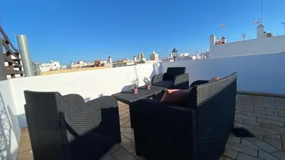 a patio with two chairs and a table on a roof at Hope's ático-apartamento in Cádiz
