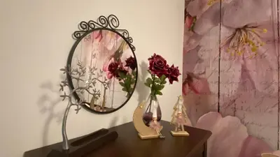 a table with a mirror and a vase with flowers at Hope's ático-apartamento in Cádiz