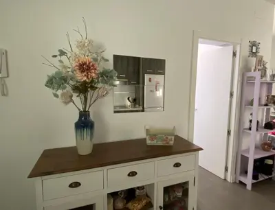 a vase of flowers on a cabinet in a room at Hope's ático-apartamento in Cádiz