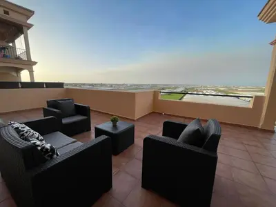 a living room with couches and chairs on a balcony at El Mirador del Coto, Apartamentos Living Sur in Sanlúcar de Barrameda