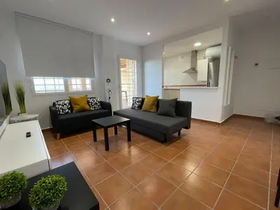 a living room with two couches and a table at El Mirador del Coto, Apartamentos Living Sur in Sanlúcar de Barrameda