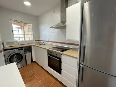 a kitchen with a stainless steel refrigerator and a dishwasher at El Mirador del Coto, Apartamentos Living Sur in Sanlúcar de Barrameda