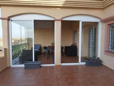 a patio with sliding glass doors on a house at El Mirador del Coto, Apartamentos Living Sur in Sanlúcar de Barrameda
