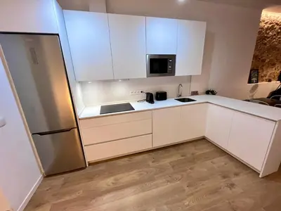 a kitchen with white cabinets and a refrigerator at GATU PREMIUM Villa La Pepa in Cádiz