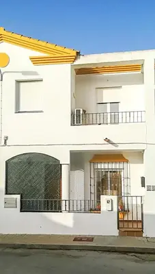 a white building with a gate and a balcony at Apartamento Sol y Sal in Chiclana de la Frontera