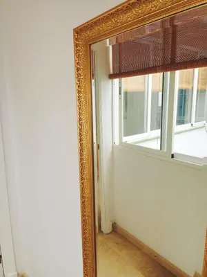 a mirror in a room with a window at Azvalia - Larga 112 in El Puerto de Santa María
