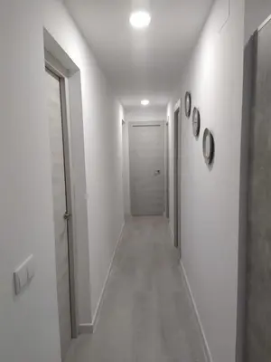 a hallway with white walls and a white door at Villa Romadian in Chiclana de la Frontera
