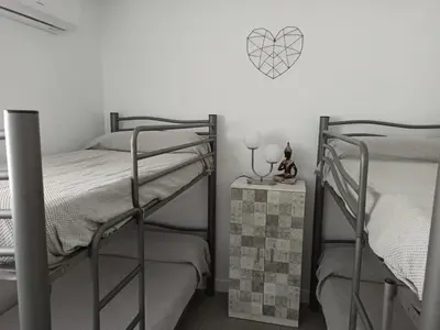 a bedroom with two bunk beds and a table with a night stand at Angkor Wat Village in Puerto Real