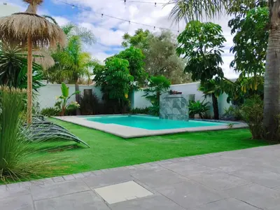 a swimming pool in a yard with green grass at Angkor Wat Village in Puerto Real