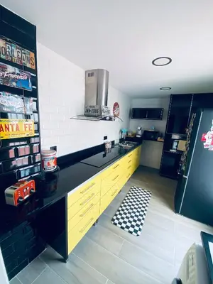 a kitchen with yellow cabinets and a black refrigerator at Texas Life Apartamento Centro Jerez in Jerez de la Frontera