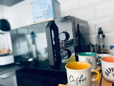 a microwave on a counter with two cups of coffee at Texas Life Apartamento Centro Jerez in Jerez de la Frontera