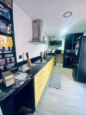 a kitchen with yellow cabinets and a black refrigerator at Texas Life Apartamento Centro Jerez in Jerez de la Frontera