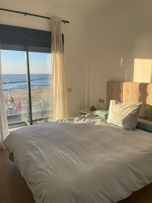 a bedroom with a bed with a view of the beach at Apartamento con piscina en el Paseo Cruz del Mar in Chipiona