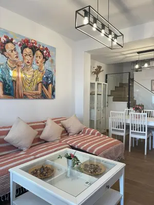 a living room with a couch and a painting on the wall at Apartamento con piscina en el Paseo Cruz del Mar in Chipiona
