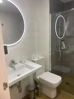 a bathroom with a sink and a toilet and a mirror at Apartamento con piscina en el Paseo Cruz del Mar in Chipiona