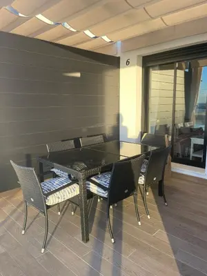 a dining room with a black table and chairs at Apartamento con piscina en el Paseo Cruz del Mar in Chipiona