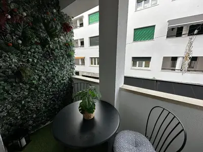 a table and chairs in a balcony with a plant on it at BASTINAZO ALOHADREAM - PREMIUM - La mejor ubicación con Aire Acondicionado, Insonorización, Terraza y Equipamiento en El Puerto de Santa María - Grupo de solo menores de 25 no aceptados salvo fianza adicional in El Puerto de Santa María