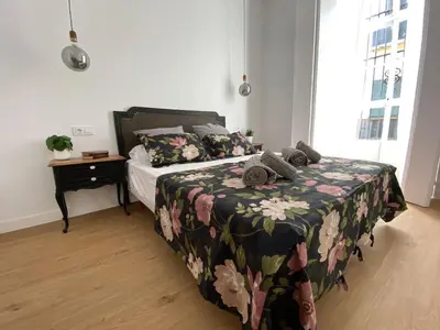 a bedroom with a bed with a floral bedspread at Azvalia - Puro Puerto Casco Histórico in El Puerto de Santa María