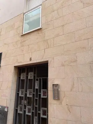 a brick building with a window with photos on it at Hercules in Cádiz
