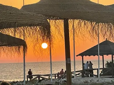 a group of people standing on a beach at sunset at Hochwertiges Haus in wunderschöner Golf Anlage am Meer in Rota