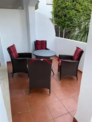 a patio with a table and chairs on a balcony at Hochwertiges Haus in wunderschöner Golf Anlage am Meer in Rota