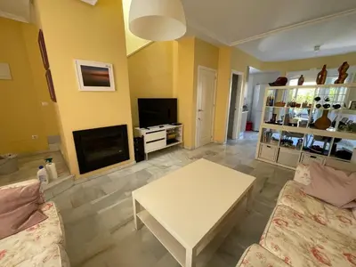 a living room with a couch and a table at Hochwertiges Haus in wunderschöner Golf Anlage am Meer in Rota