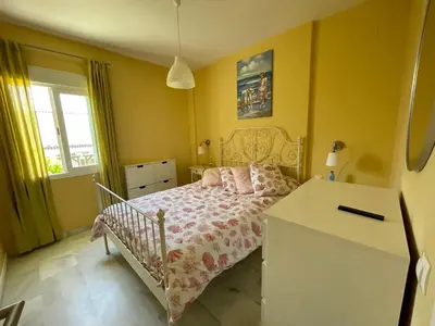 a small bedroom with a bed and a desk at Hochwertiges Haus in wunderschöner Golf Anlage am Meer in Rota