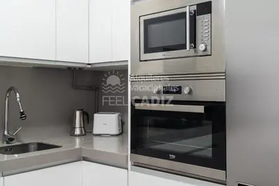 a kitchen with a microwave and a sink at Apartamento San Agustín Feel Cádiz in Cádiz