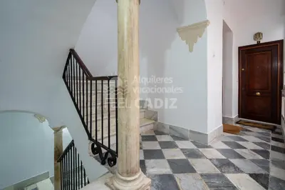 a staircase with a column and a checkered floor at Apartamento San Agustín Feel Cádiz in Cádiz