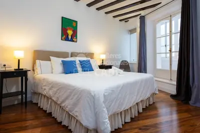 a bedroom with a large white bed with blue pillows at Apartamento San Agustín Feel Cádiz in Cádiz