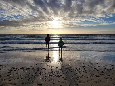 a man and a child standing on the beach at El Mirador de Inés - Primera Línea de Playa in El Puerto de Santa María