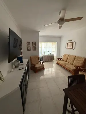 a living room with a couch and a tv at Chalet en La Barrosa, Piscina+BBQ+Grifo de Cerveza in Chiclana de la Frontera