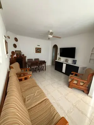 a living room with a couch and chairs and a television at Chalet en La Barrosa, Piscina+BBQ+Grifo de Cerveza in Chiclana de la Frontera