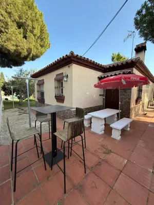 a patio with a table and chairs and an umbrella at Chalet en La Barrosa, Piscina+BBQ+Grifo de Cerveza in Chiclana de la Frontera