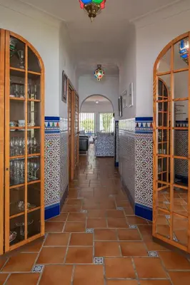 a hallway in a house with a tile floor at Villa La Contenta jardín y piscina en Conil centro in Conil de la Frontera