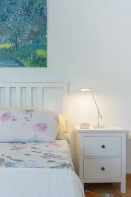 a bedroom with a bed and a lamp and a painting at Villa La Contenta jardín y piscina en Conil centro in Conil de la Frontera