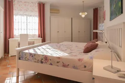 a bedroom with a bed and a lamp in it at Villa La Contenta jardín y piscina en Conil centro in Conil de la Frontera