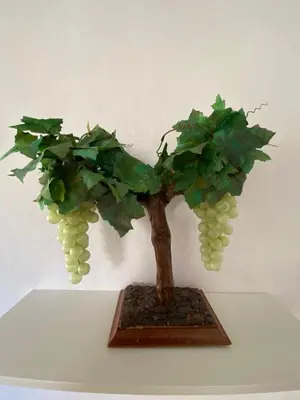 a bonsai tree with grapes on a white wall at LA VENDIMIA in Jerez de la Frontera