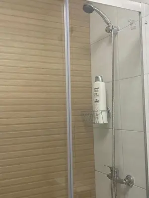 a shower with a glass door with a bottle of shampoo at LA VENDIMIA in Jerez de la Frontera