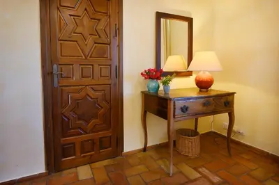 a room with a door and a table with a lamp at Cortijo de Guerra in Puerto Real