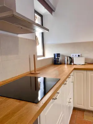 a kitchen with white cabinets and a black microwave at Cortijo de Guerra in Puerto Real