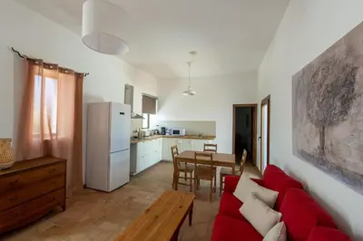 a living room with a red couch and a table at Cortijo de Guerra in Puerto Real