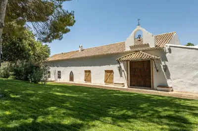 an exterior view of a church with a yard at Cortijo de Guerra in Puerto Real