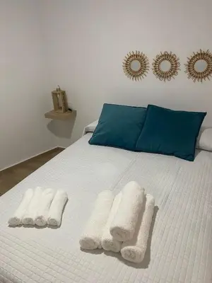 a white bed with two white towels on it at EL VENENCIADOR in Jerez de la Frontera