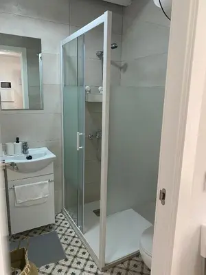 a bathroom with a glass shower and a sink at EL VENENCIADOR in Jerez de la Frontera