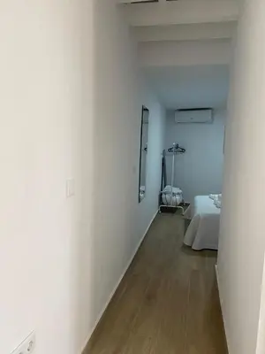 a white room with a bed and a mirror at EL VENENCIADOR in Jerez de la Frontera